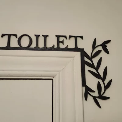 Une signalétique de coin de porte de toilettes